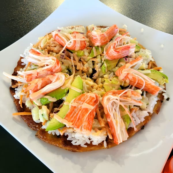 Fusion Tea Lounge's sushi waffle with crab, avocado, rice, and sauce on a white plate.