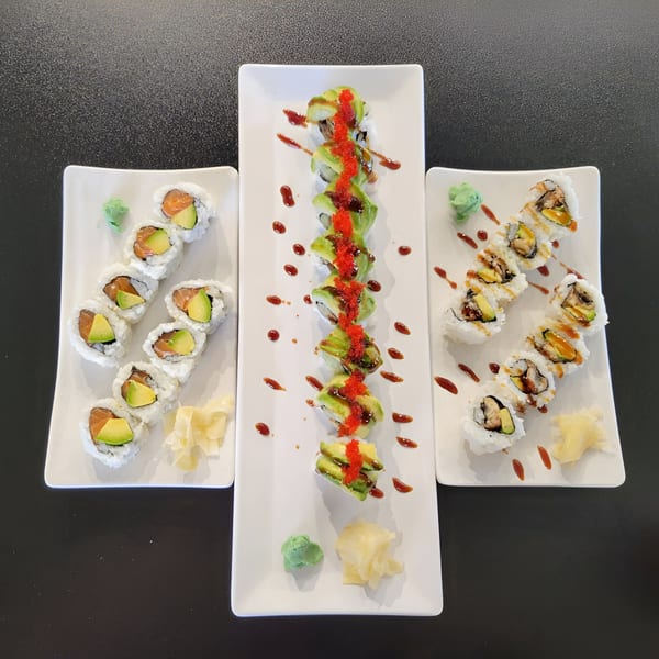 Three plates of sushi rolls, including salmon avocado, dragon, and eel rolls, with wasabi and ginger.